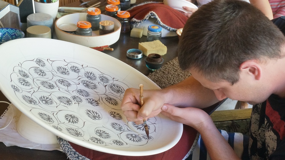 ウズベキスタンのリシタン陶器の柄模様を書いている男性