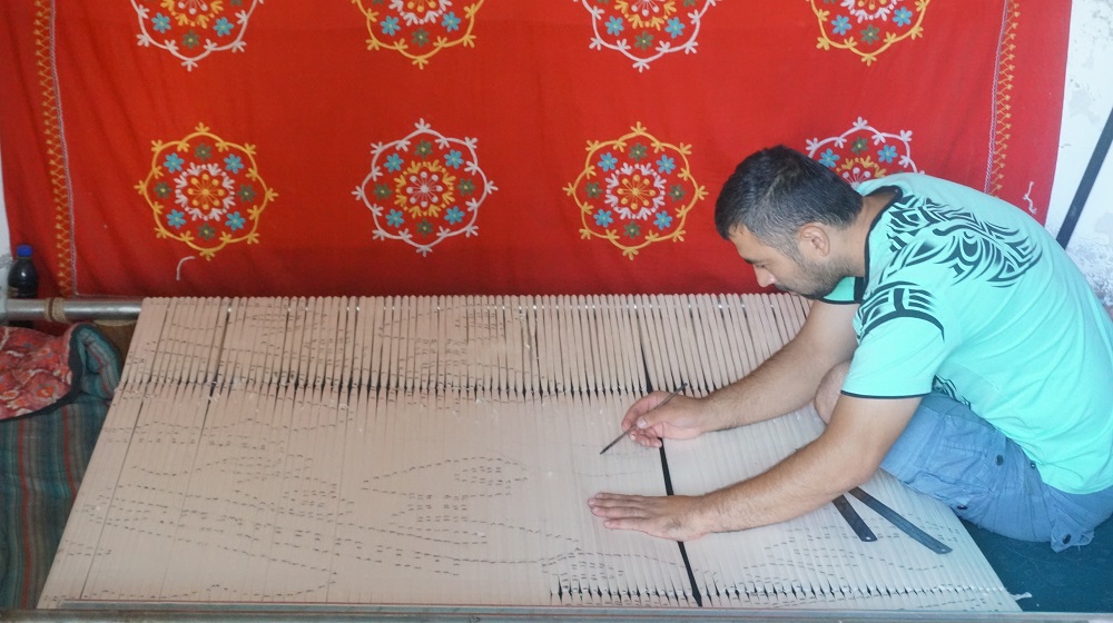 ウズベキスタンの絣工房にてデザインする男性