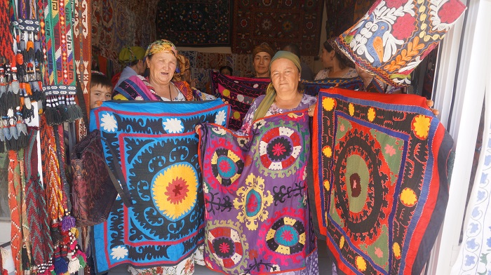 大きなカラフルなスザニ刺繍を売る女性たち
